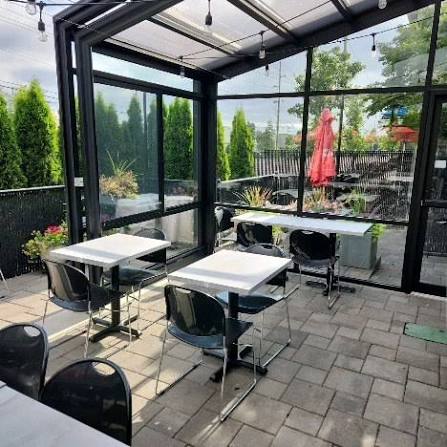 My Bar's covered patio — glass roof, greenery and sunshine